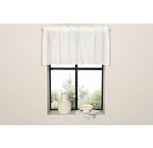 Gardin framför ett fönster med dekorationer på fönsterbrädan