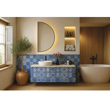 Badrum med tvättställ, spegel, badkar och blått kakel med mönster