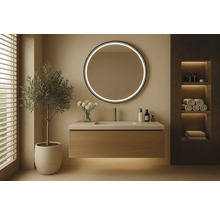 Modernt badrum med tvättställ, rund spegel med belysning och dekorationer.