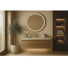 Modernt badrum med rund spegel, tvättställsskåp och hylla