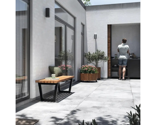 Modern uteplats med träbänk, växtlåda och utekök