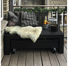 Balkongmöbler med kuddar och dekoration på en balkong med trägolv och tegelvägg