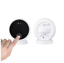 Två runda övervakningskameror med rörelsesensor och kontroller, en hand rör strömknappen