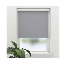 Grå rullgardin vid fönstret för ljusreglering och avskildhet.