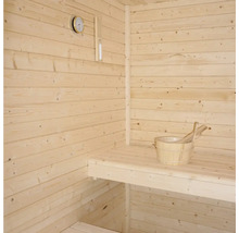 Bastu med träväggar, sittbänk, termometer och trähink med skopa