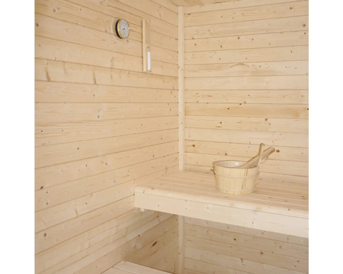 Bastu med träväggar, sittbänk, termometer och trähink med skopa