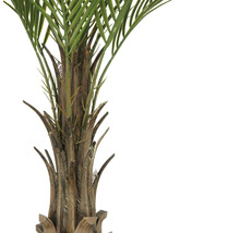 Närbild av en konstgjord palm med ett grönt bladverk och en brun stam