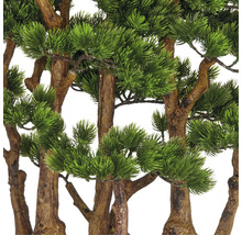 Närbild av konstgjorda tallgrenar med bruna stammar och gröna barr.