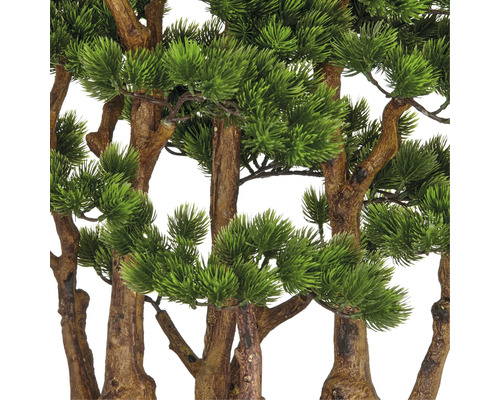 Närbild av konstgjorda tallgrenar med bruna stammar och gröna barr.