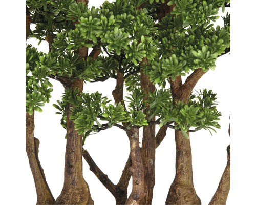 Detaljbild av konstgjorda träd med gröna löv och bruna stammar.