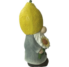 Trädgårdstomte med citron som huvud och solros i handen