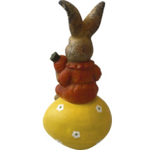 Dekorativ kanin på ett påskägg med en morot i handen som trädgårdsdekoration