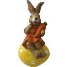 Dekorativ kaninfigur med morot på gult ägg till påsk