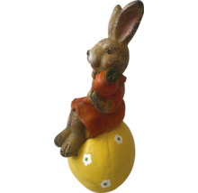 Påskhare på ett gult ägg som trädgårdsdekoration