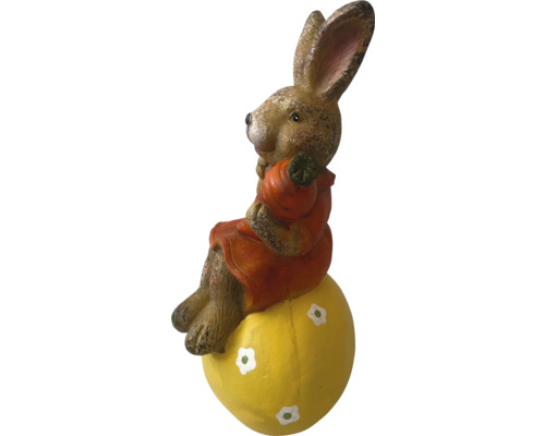 Påskhare på ett gult ägg som trädgårdsdekoration