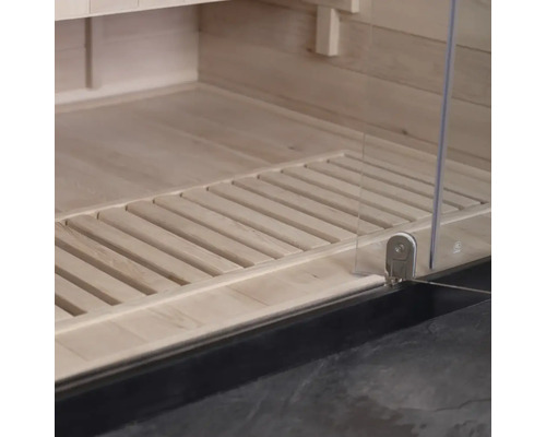 Detaljvy av en bastuinteriör med trägolv och glasdörr