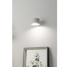 Vägglampa bredvid en inramad bild på väggen