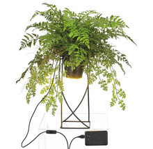 Konstgjord ormbunke i kruka på metallstativ med elanslutning