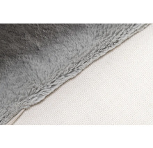 Detaljbild av en grå mjuk filt med vit undersida.