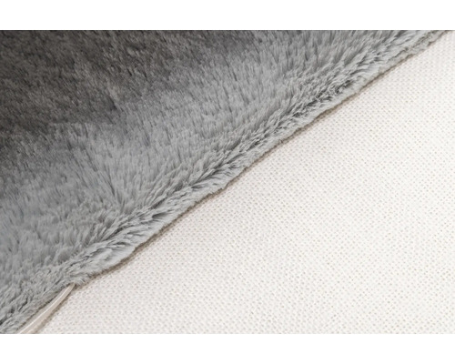 Detaljbild av en grå mjuk filt med vit undersida.