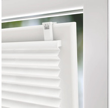 Detaljvy av en vit plisségardin på ett fönster