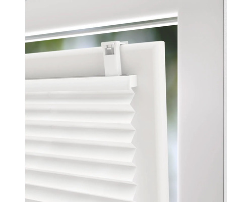 Detaljvy av en vit plisségardin på ett fönster