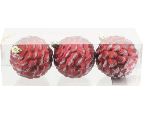 Tre röda julgranskulor i form av en tallkotte i transparent förpackning