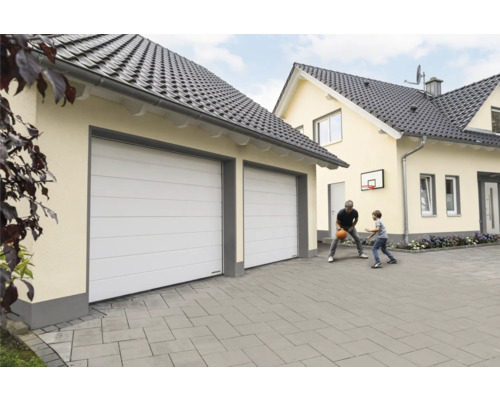 Garage med två sektionsportar framför en villa