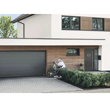 Modernt hus med garageport, ytterdörr och träpanel