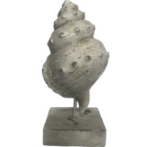 Dekorativ skulptur av en havssnäcka på sockel