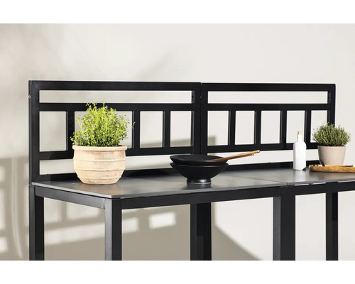 Trädgårdsbord med örtkrukor och köksredskap