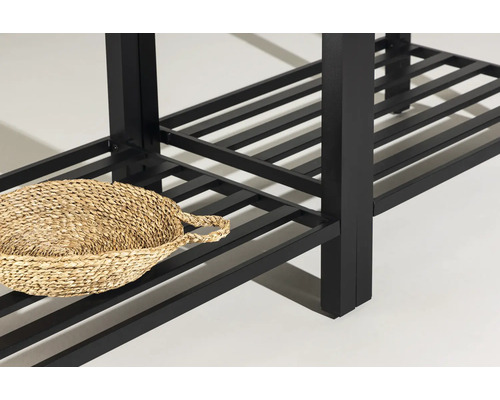 Detaljvy av en svart hylla med en korg av naturmaterial.