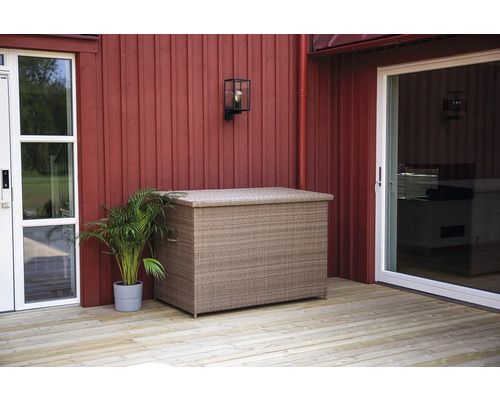 Flätad förvaringslåda på en träterrass framför ett hus.