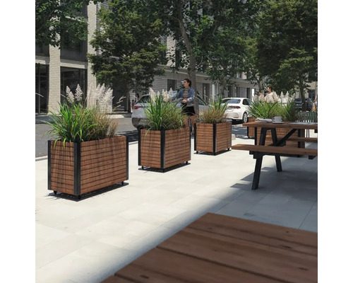 Utomhusscen med blomlådor i trä och metall samt en picknickbänk i trä och metall.