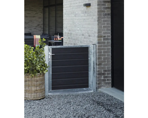 Trädgårdsscen med en liten grind av metall och trä