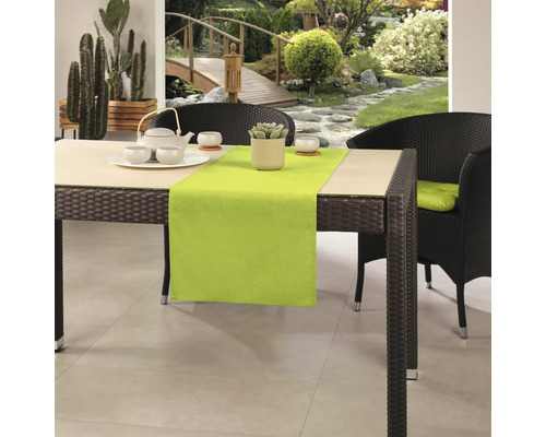 Matbord med bordslöpare, porslin och trädgårdsutsikt