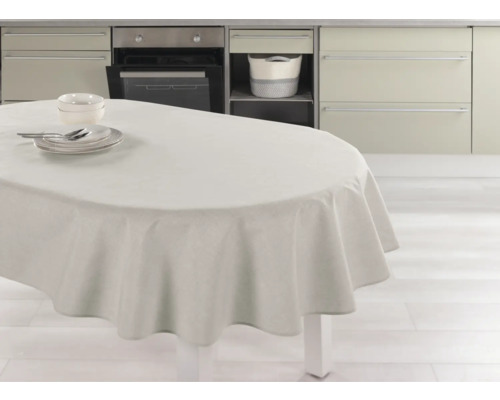 Ett matbord med en duk och porslin i ett ljust kök.