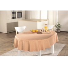 Dukat matbord med duk, juice, frukt och porslin i ett ljust kök.