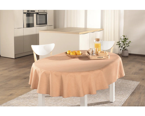 Dukat matbord med duk, juice, frukt och porslin i ett ljust kök.