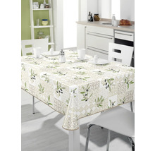 Bord med olivmönstrad duk i ett ljust kök