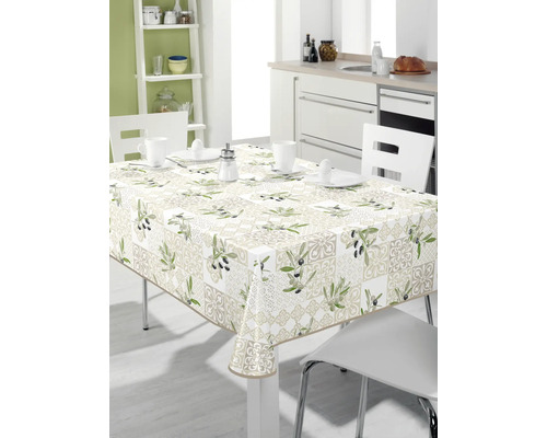 Bord med olivmönstrad duk i ett ljust kök