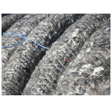 Närbild av en rulle med grått isoleringsmaterial, lindad med tråd