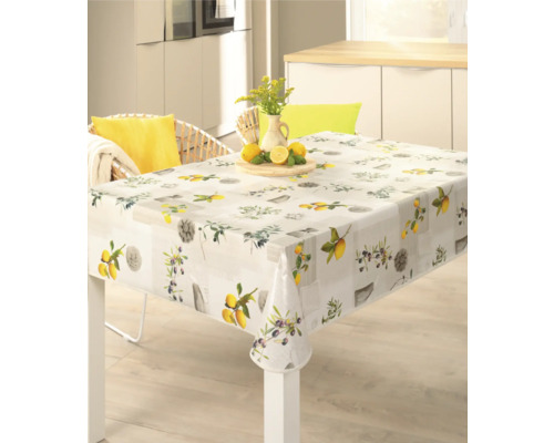 Fyrkantig duk med citron- och olivmotiv på ett matbord.
