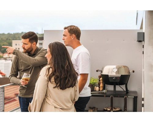 Scen med tre personer på en takterrass med grill.