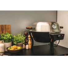 Elektrisk grill med temperaturdisplay och trädetaljer på ett bord med ingredienser