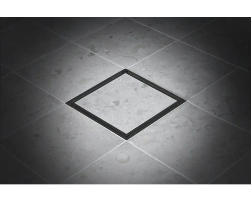 Fyrkantigt golvbrunn av metall på klinkergolv.