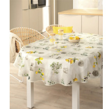 Scen med ett matbord med en rund duk, dekorerad med citronmotiv i ett ljust kök.