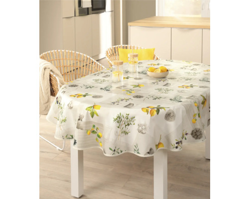 Scen med ett matbord med en rund duk, dekorerad med citronmotiv i ett ljust kök.