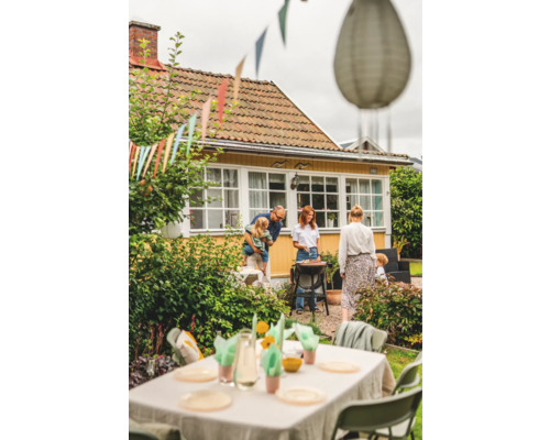 Familjebarbecue i trädgården med grill, bord och dekoration