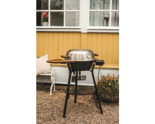 Klotgrill med termometer och trähylla i trädgården